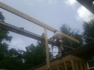 Carpenter setting a ridge beam over a new addition frame — Ice Dam Removal by Roofing Brothers in Scotland